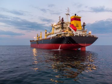 Large general cargo ship tanker bulk carrier, aerial view at night.